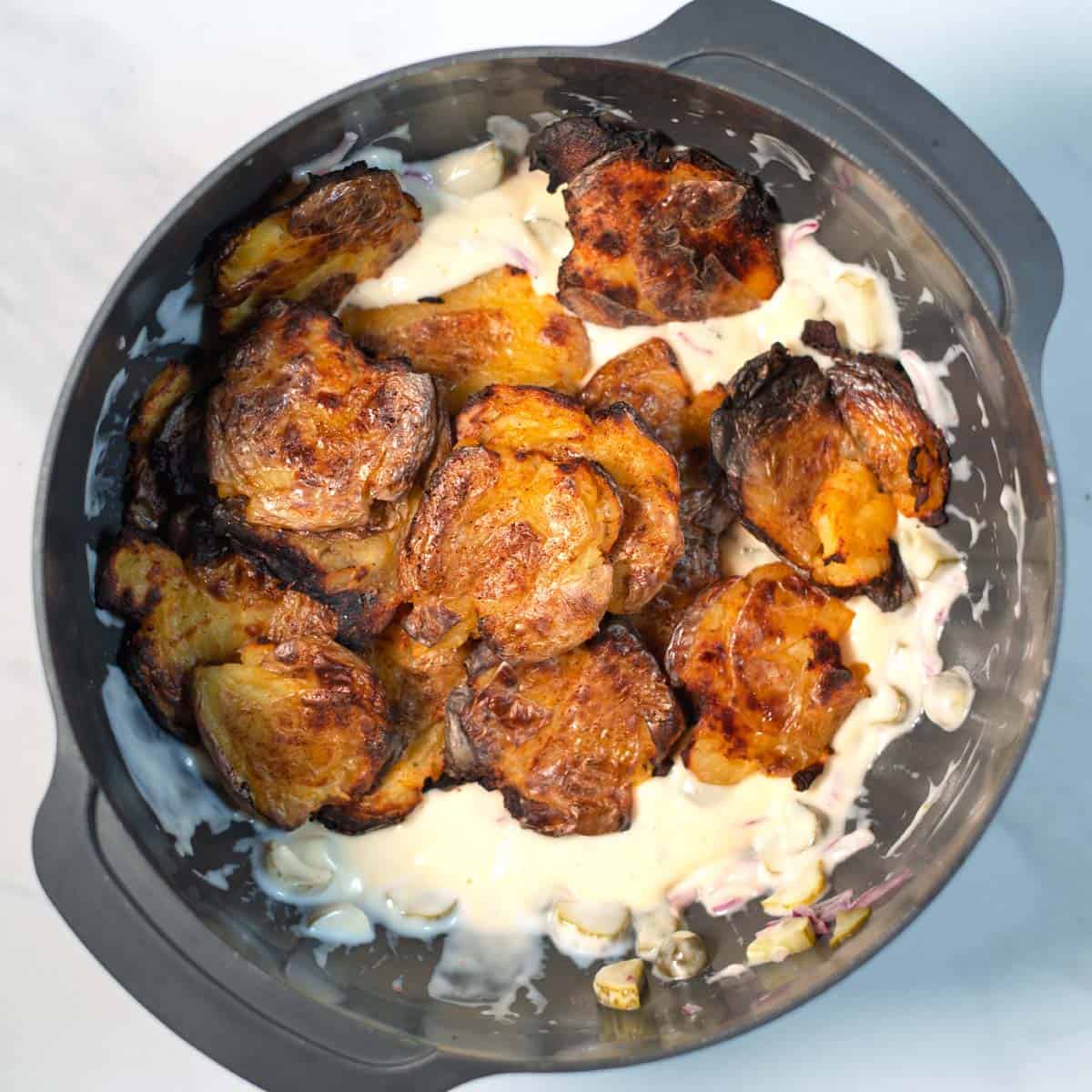 Smashed potatoes are given into the cremy pickle dressing.