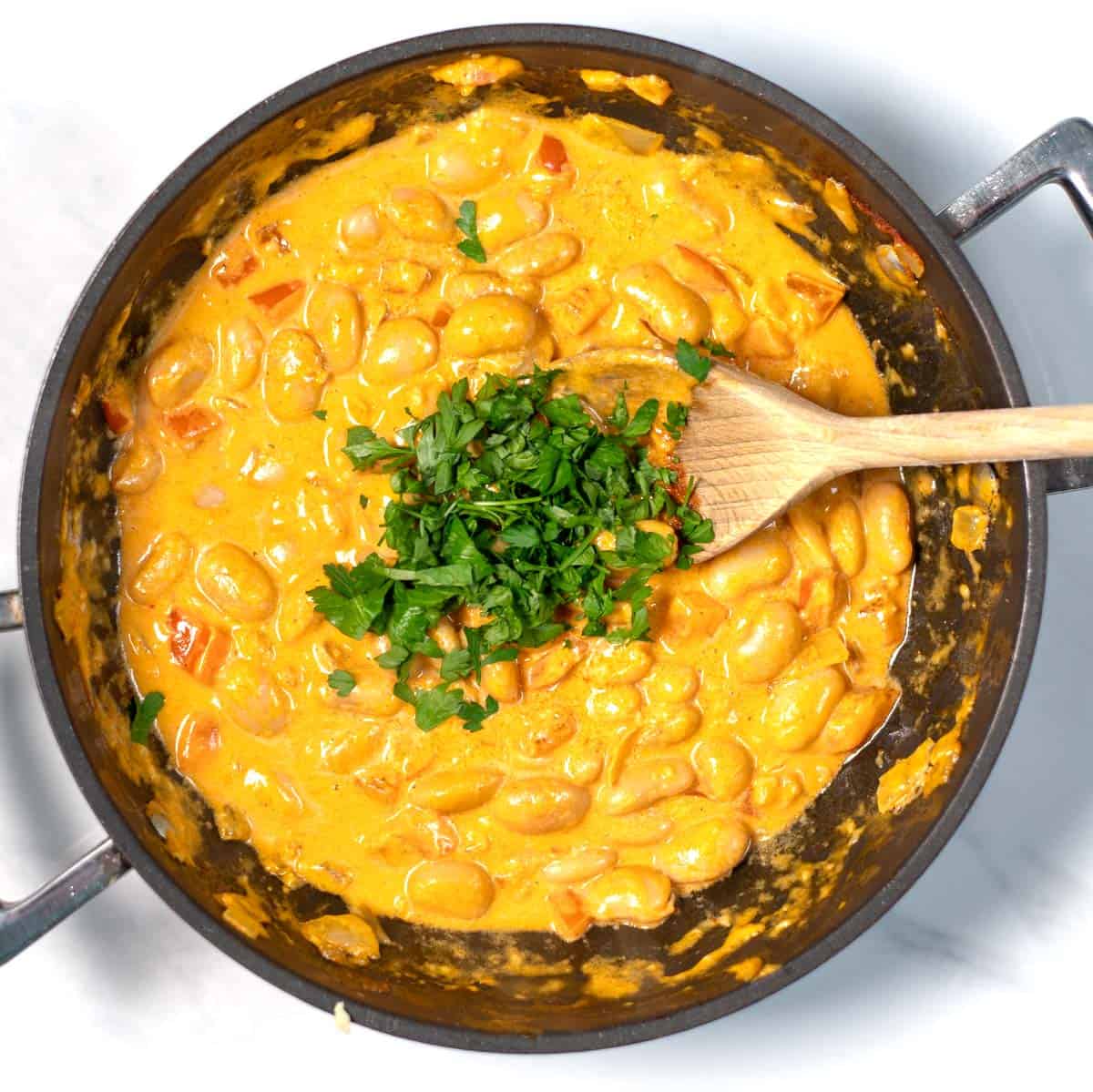 Parsley is used to garnish Creamy Harissa Butter Beans.