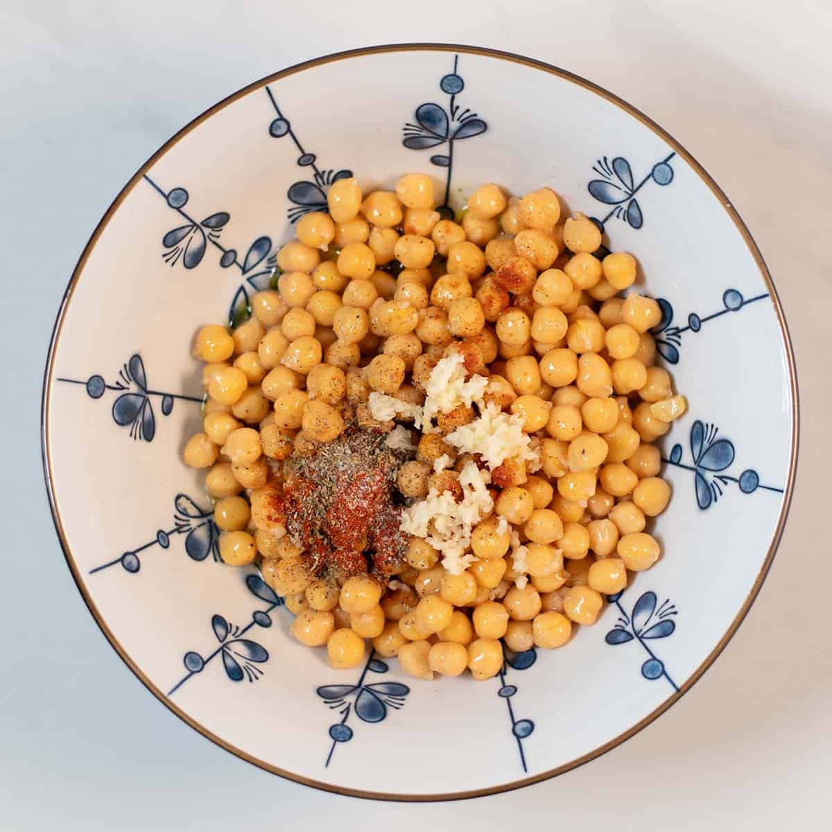 A mixing bowl with all ingredients for Marinated Chickpeas.