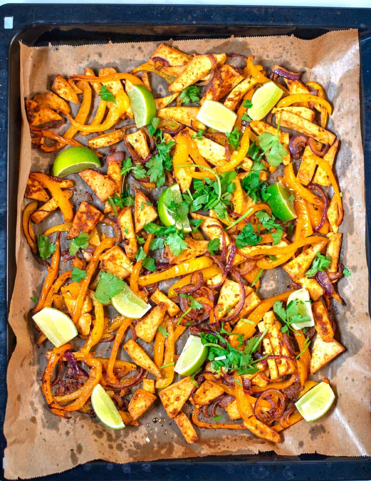 Sheet Pan Fajitas after baking, garnished with cilantro and lime.