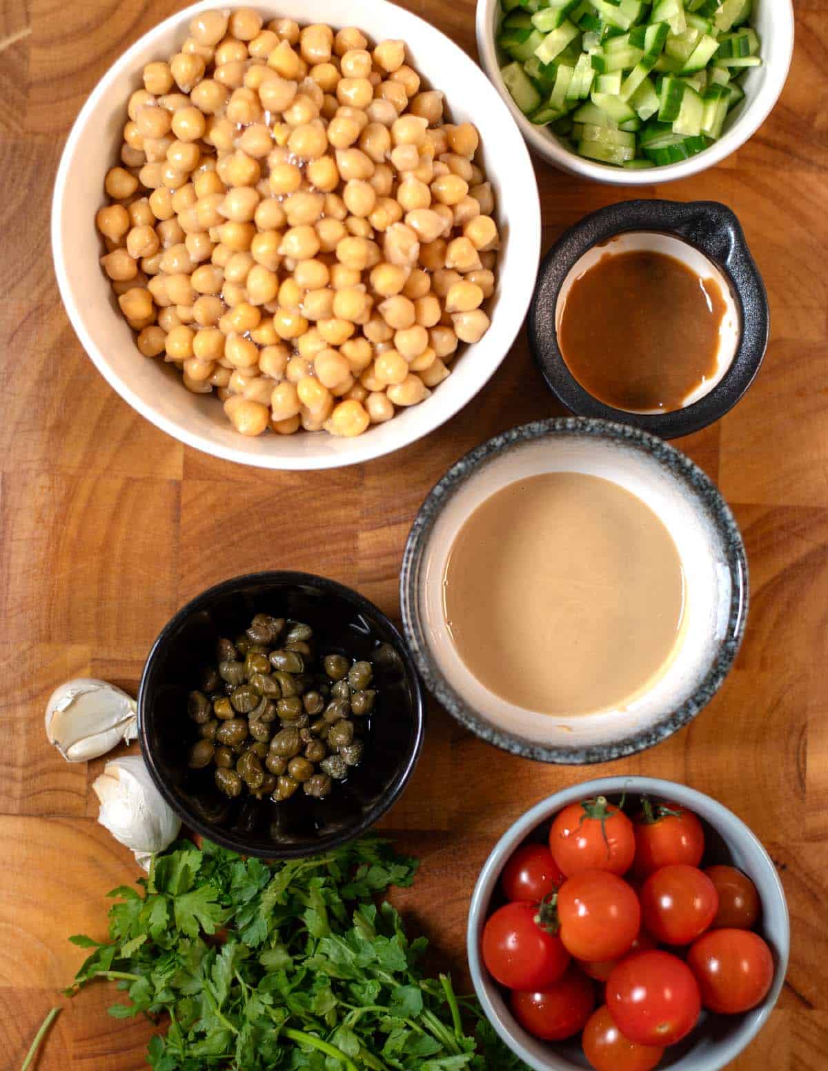 Ingredients needed to make Smashed Chickpea Salad are collected on a cutting board.