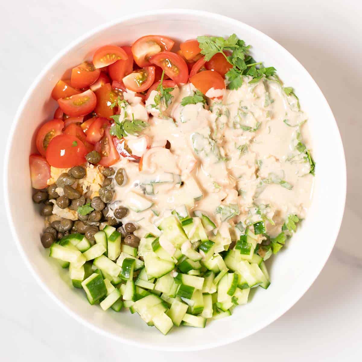 A large mixing bowl with the Smashed Chickpea Salad with the Tahini Dressing on top.