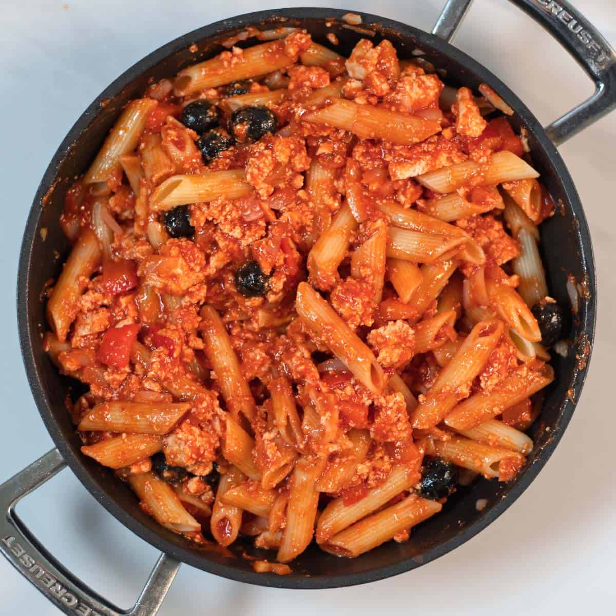 Cooked penne is mixed with the sauce.