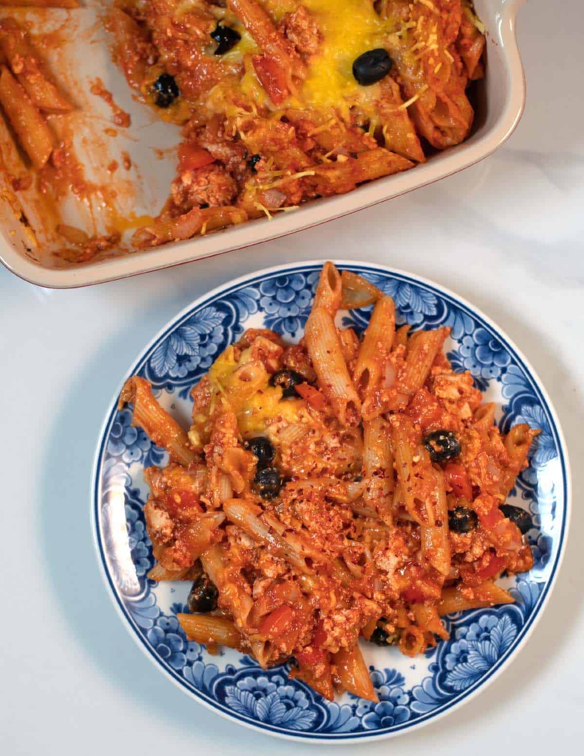 A large serving of Tofu Pasta Casserole with baking dish in the background.