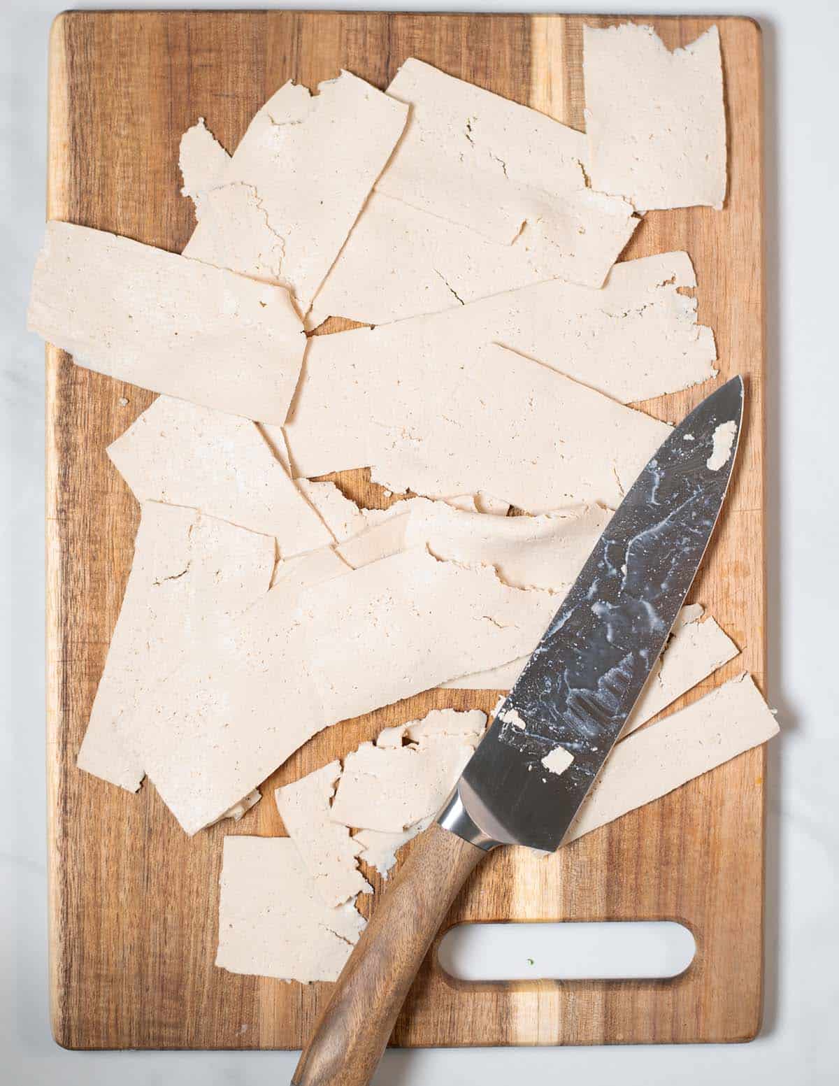 Tufo is cut into thin stripes on a vutting board.
