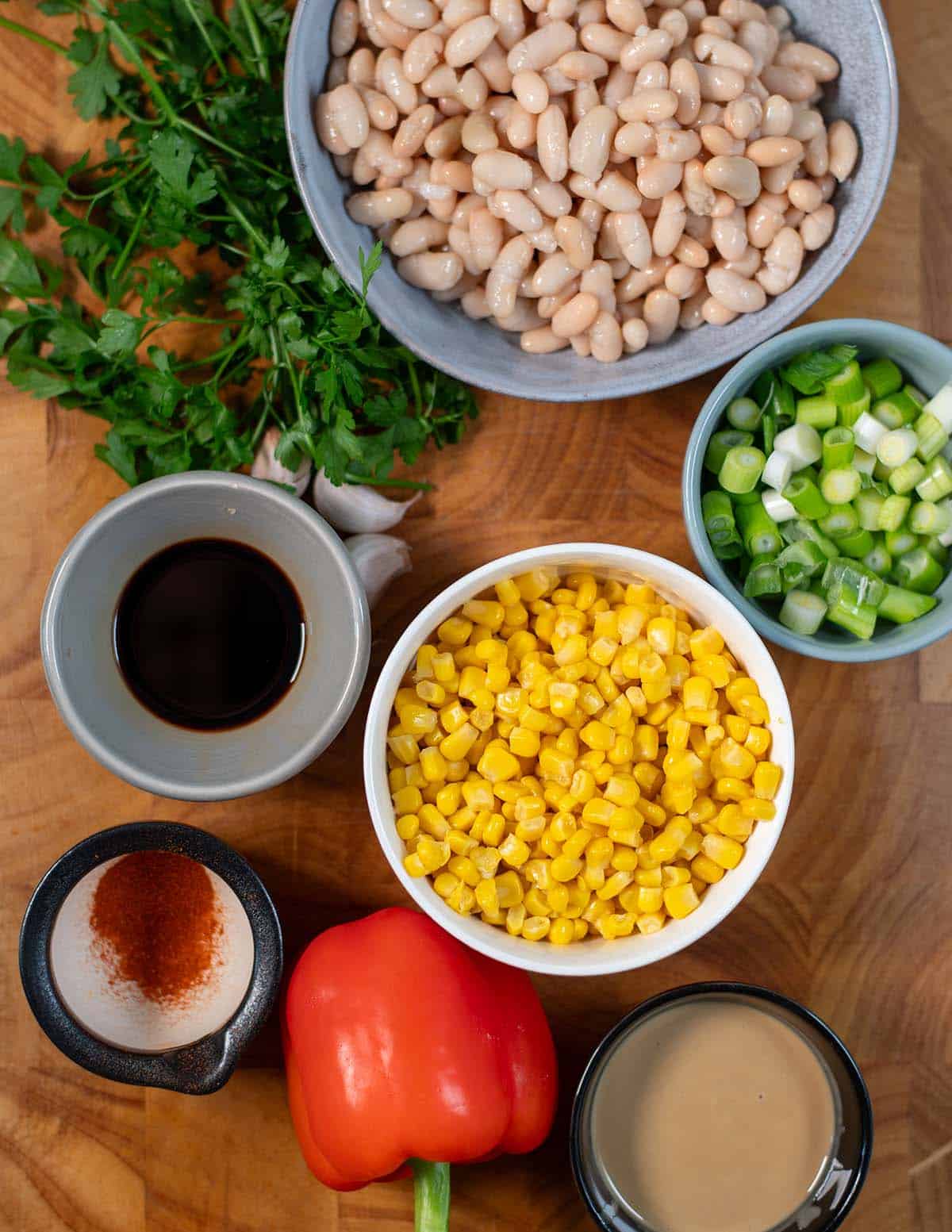 Ingredients needed to make White Bean Salad collected on a board.