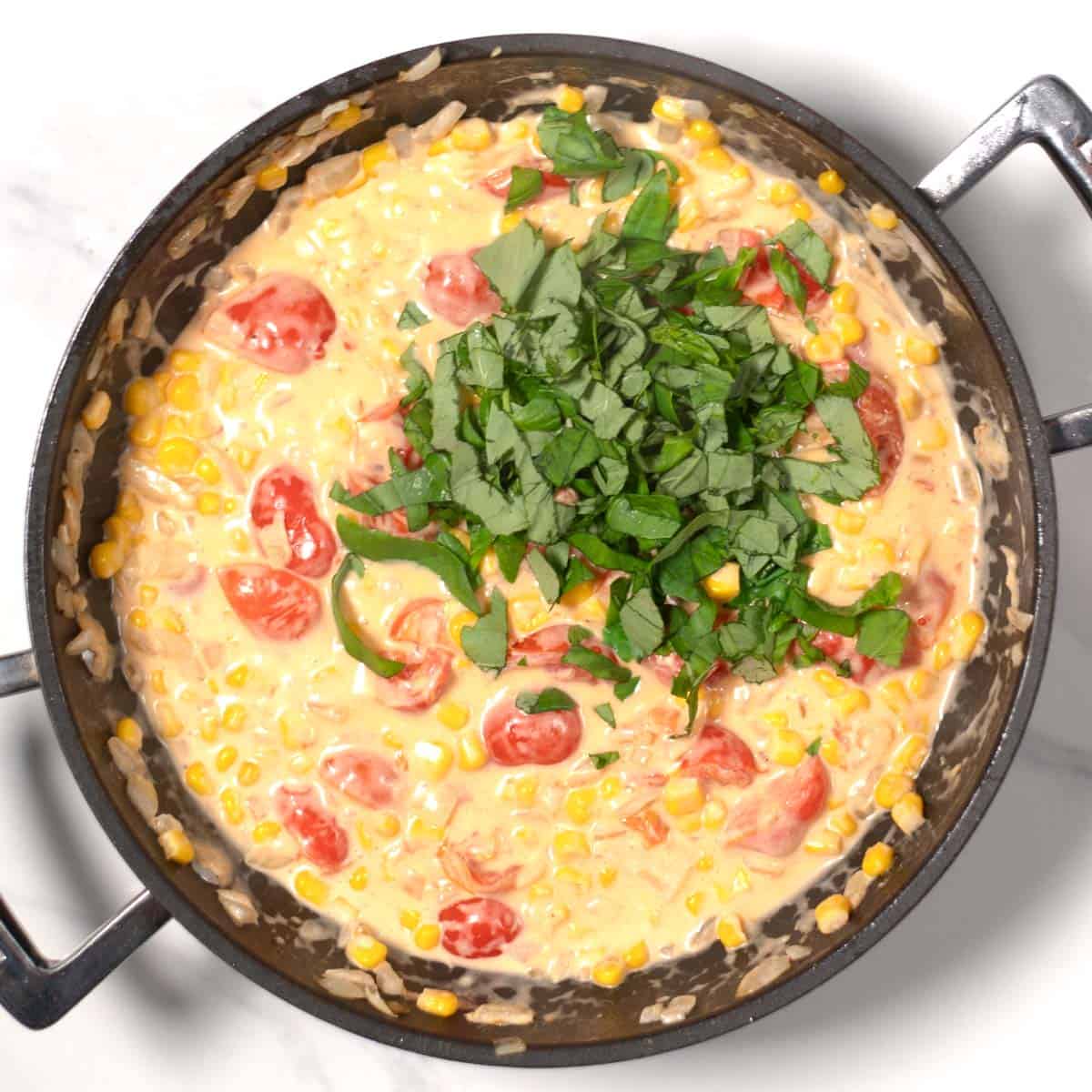 Fresh basil is added to the pan.