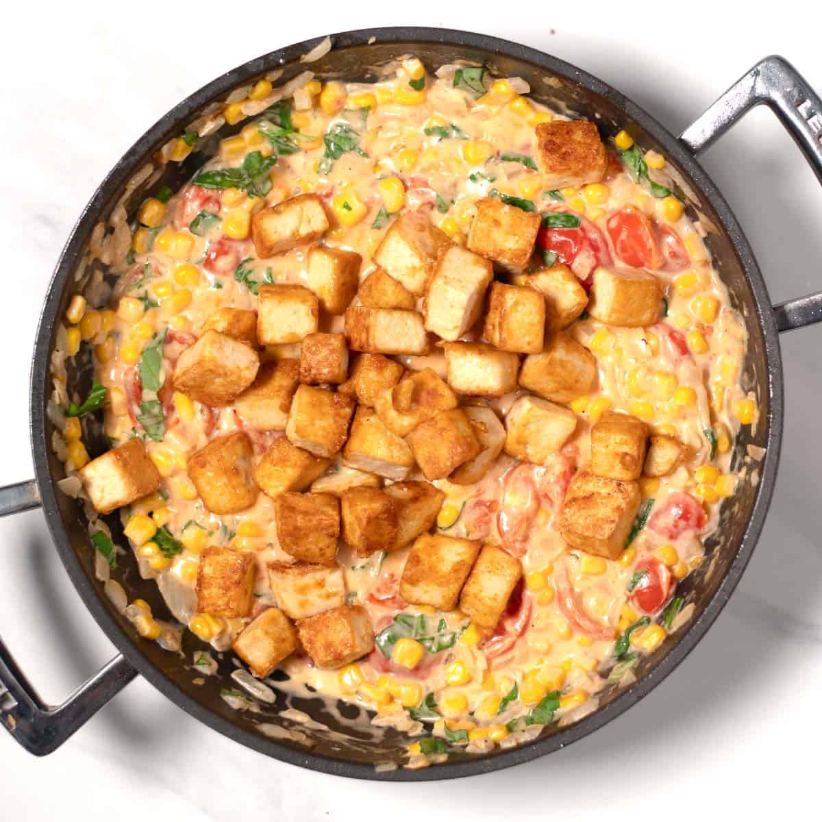 Cripsy to is added to the sauce in the pan.
