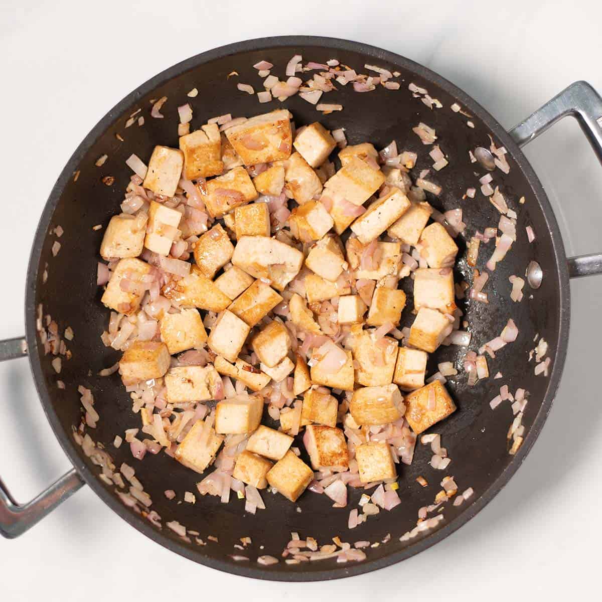 Smoked tofu and shallots are pan-fried.