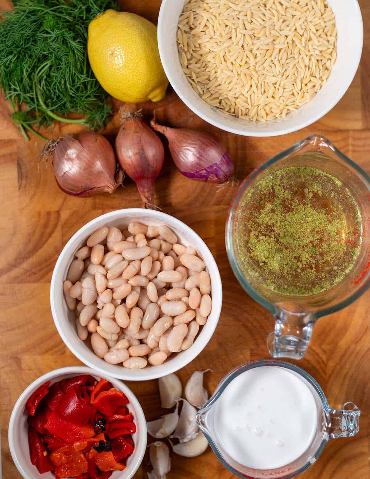 Ingredients needed to make Creamy Lemon Orzotto are collected on a board.