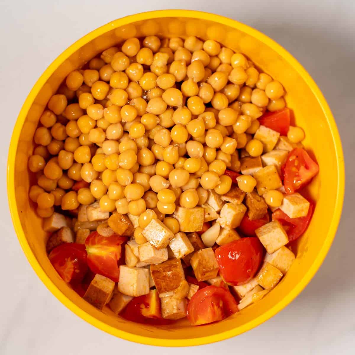 The fried ingredients and chickpeas are given into a mixing bowl.