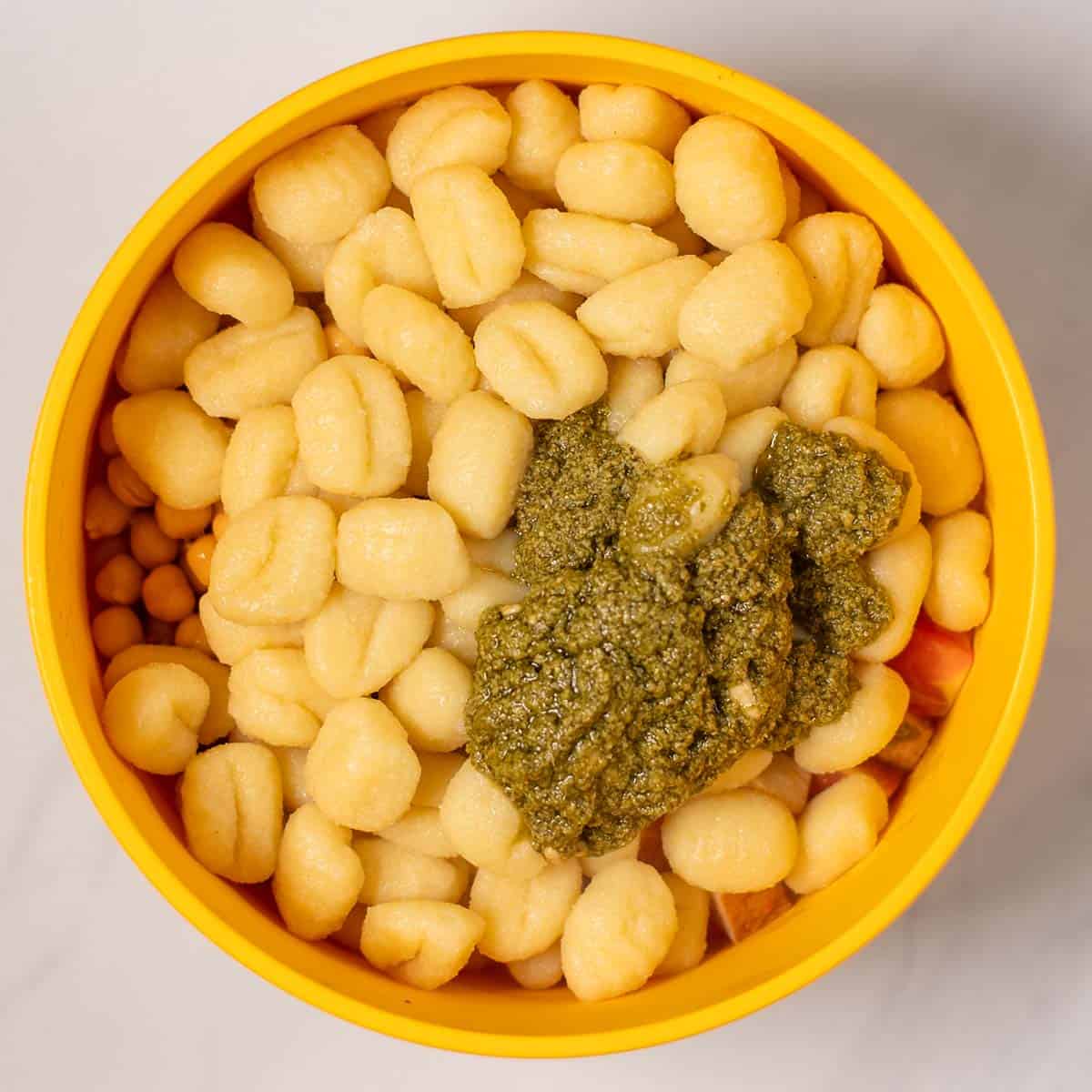 Pesto is added on top of the gnocchi.