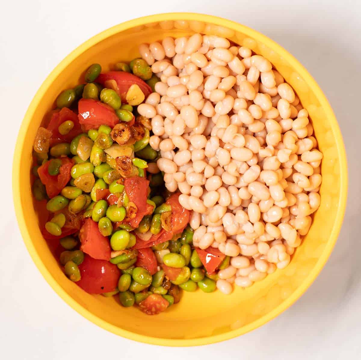 Mixing bowl with fried ingredients and chickpeas.