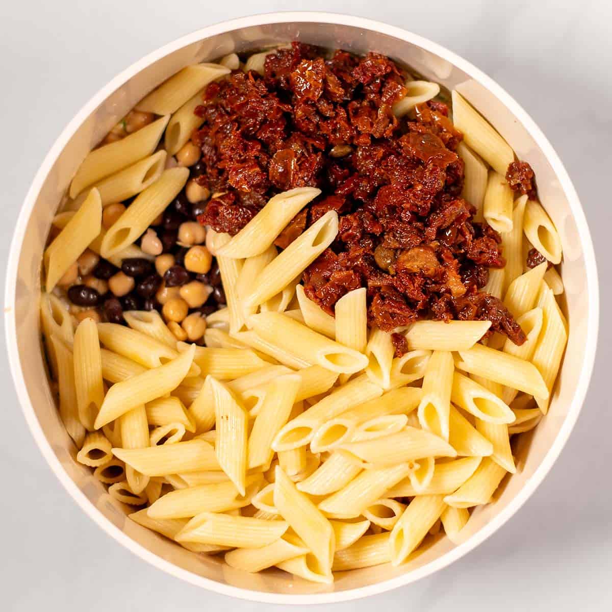 Pasta and the remaining ingredients are given into the bowl with the dressing.