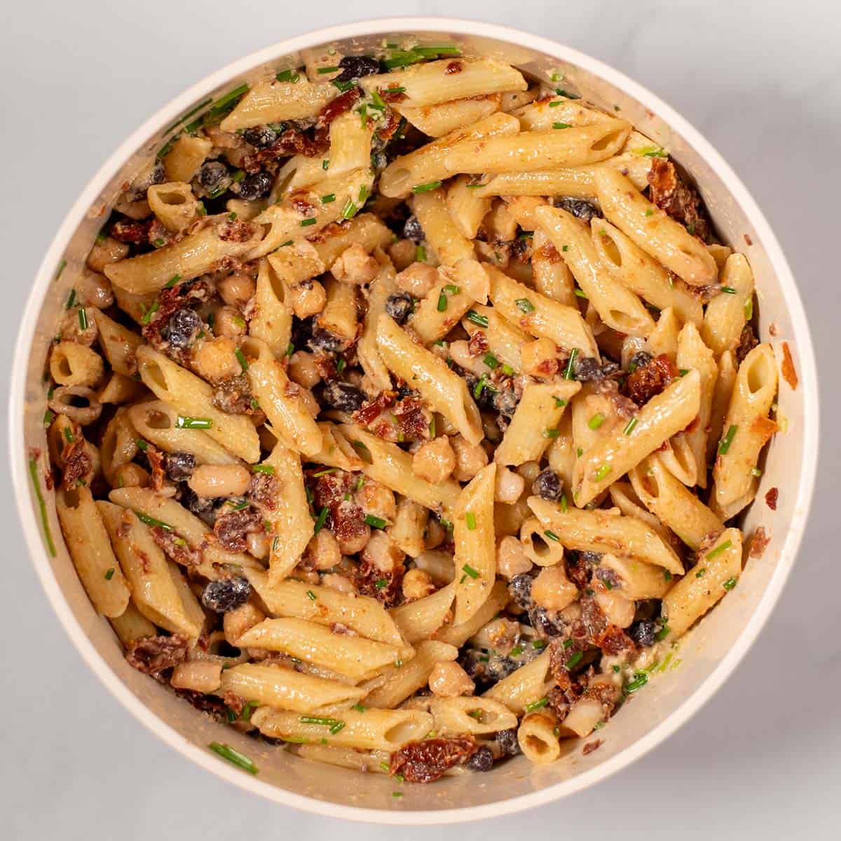 Ready mixed Three Bean Pasta Salad in a mixing bowl.