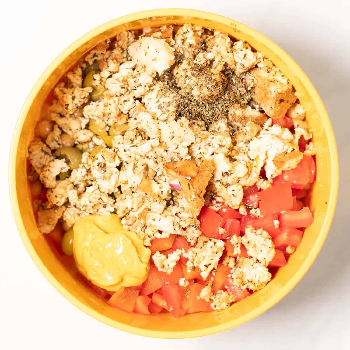 Remaining salad ingredients are added to the chickpeas in the mixing bowl.