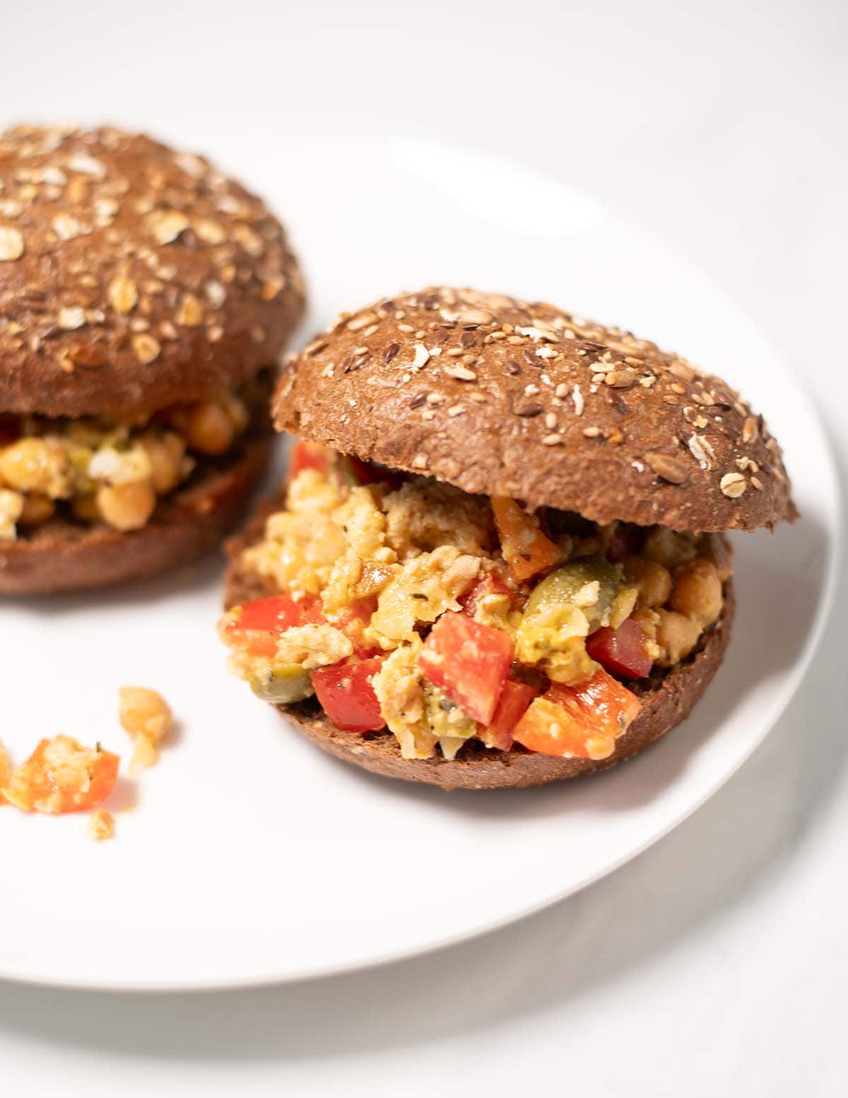 Two Chopped Salad Sandwiches on a white plate.