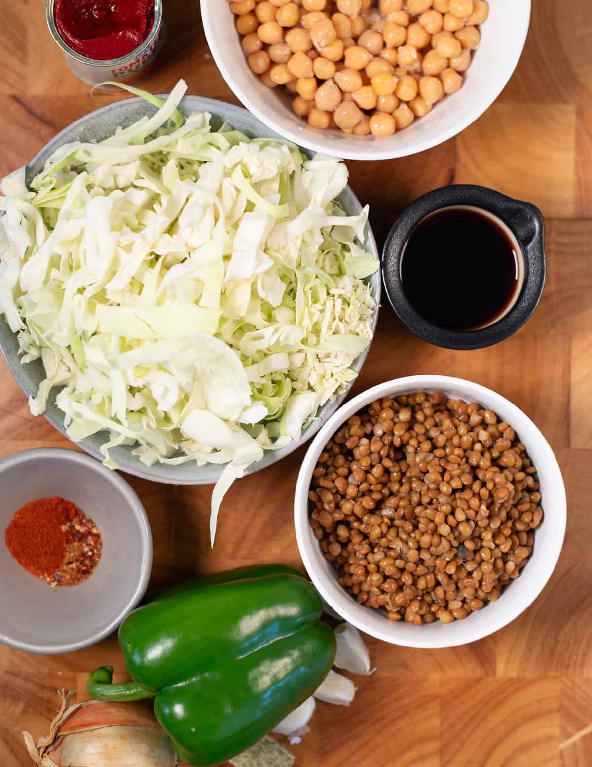 Ingredients needed to make Dirty Cabbage collected on a wooden board.