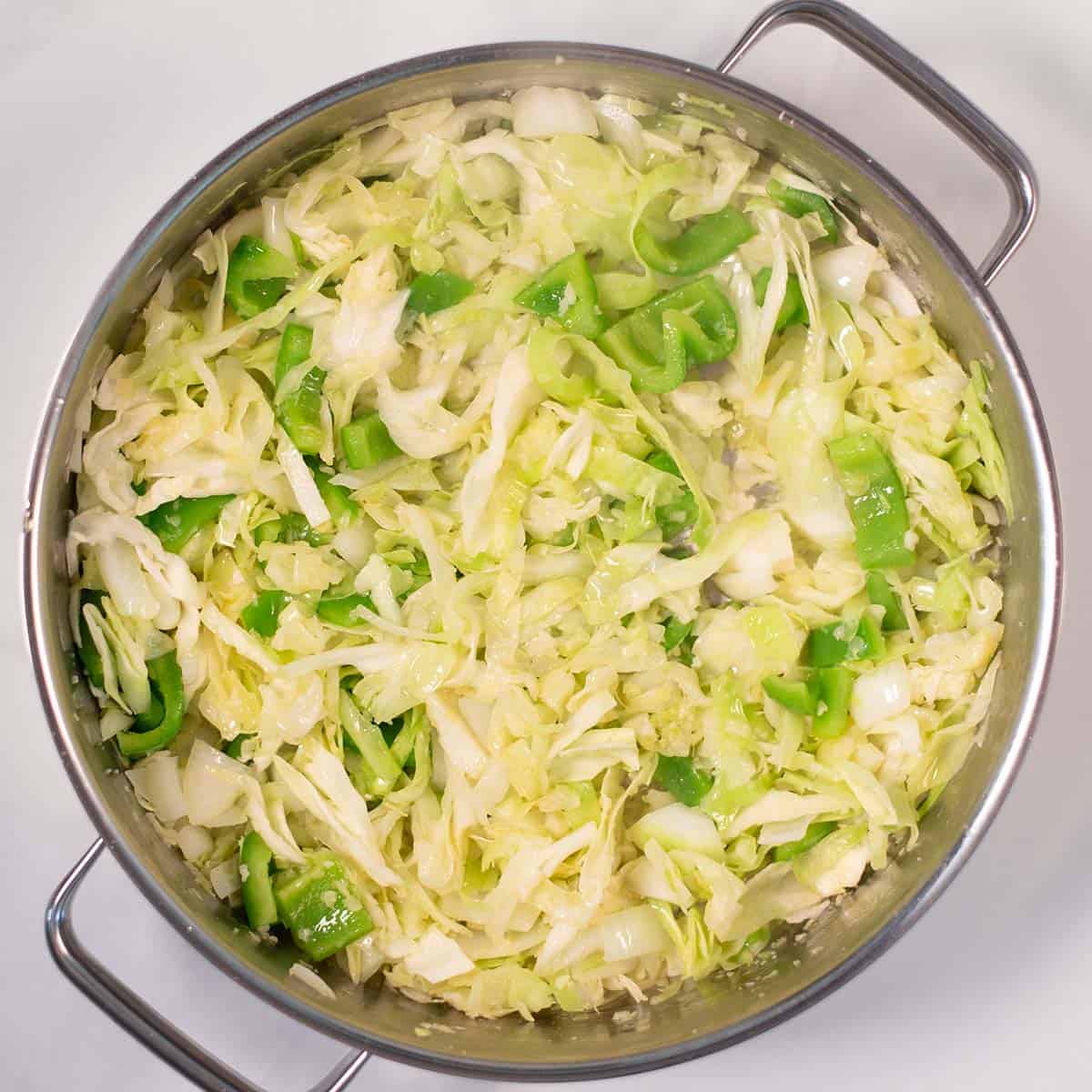 Cabbage is cooked in a pan.