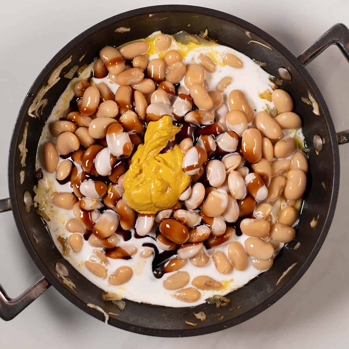 Coconut milk, mustard, balsamic are given to the pan.