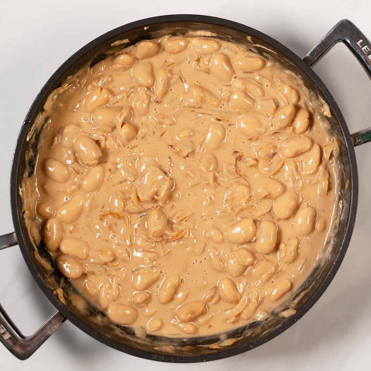 Creamy French Onion Butter Beans in a pan.