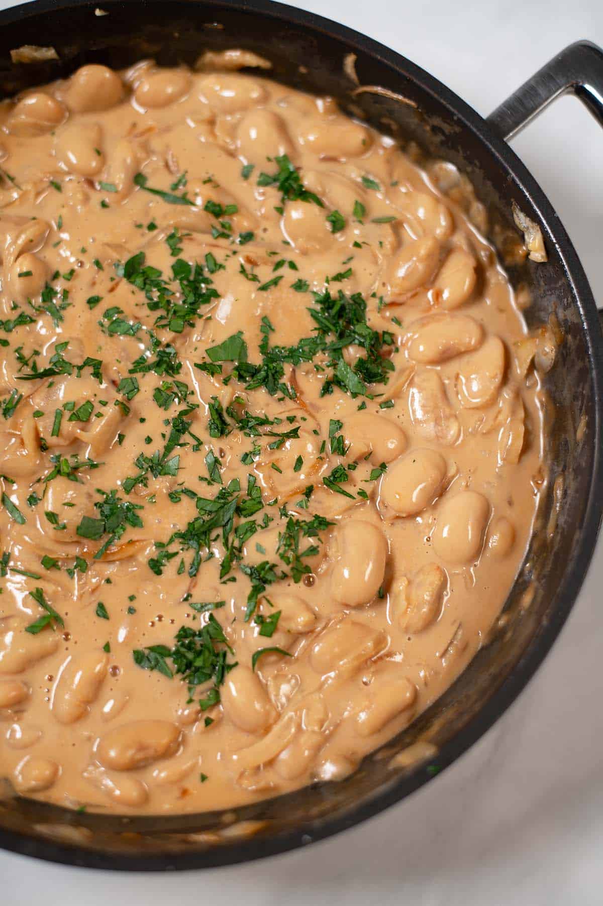 Closeup on a pan with French Onion Butter Beans.
