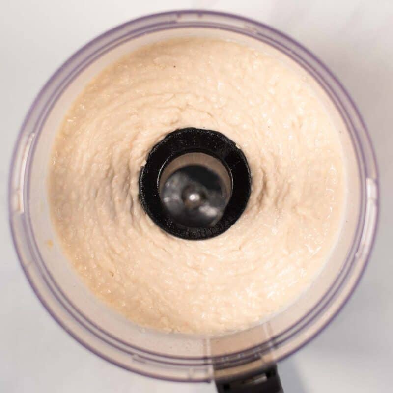 The ready white bean dip in the bowl of a food processor.