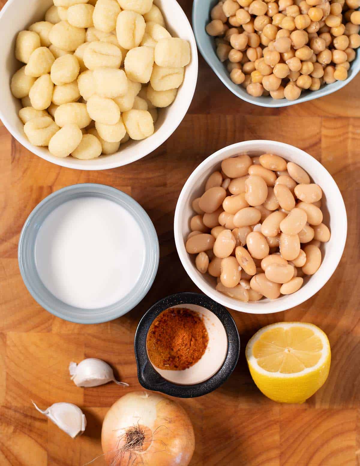Ingredients needed to make Lemon Gnocchi collected on a wooden cutting board.