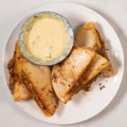 Vegan Arayes served on a plate with dipping sauce.