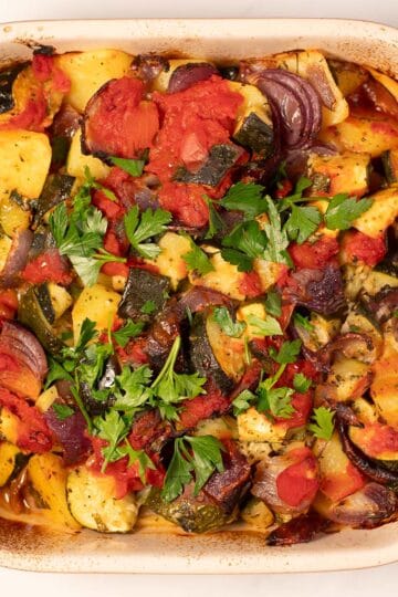 Briam as it comes out of the oven, garnished with fresh parsley.