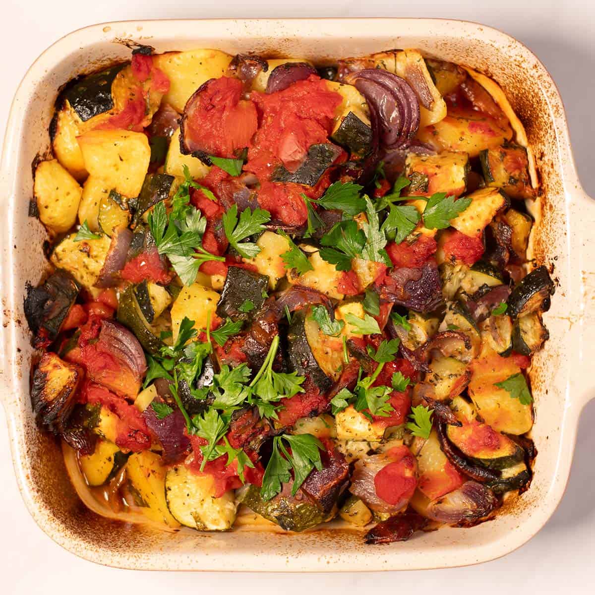 Briam as it comes out of the oven, garnished with fresh parsley.