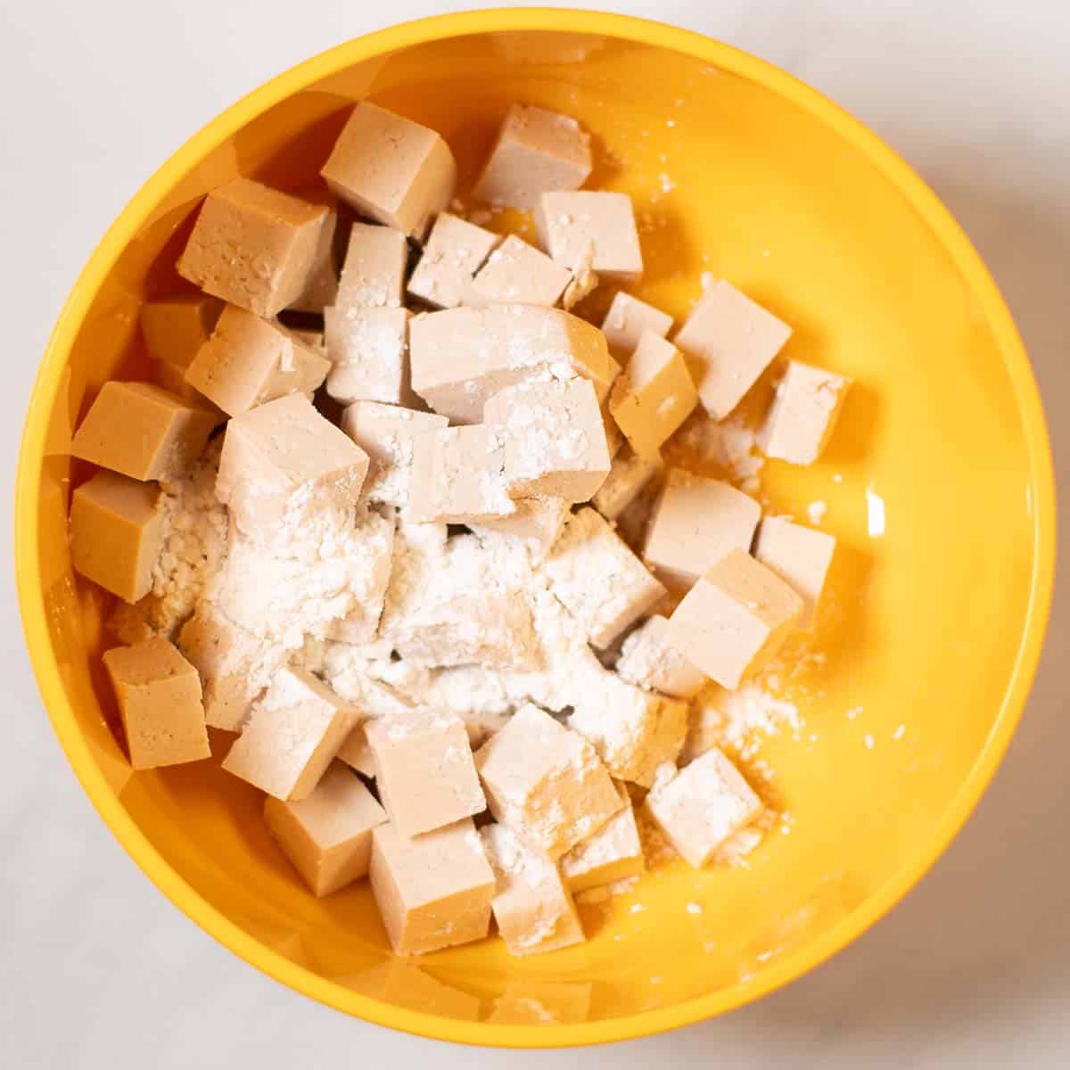 Tofu cubes are coated in cornstarch.