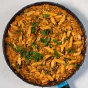 Top view of a pan with Creamy Kale pasta garnished with fresh parsley.