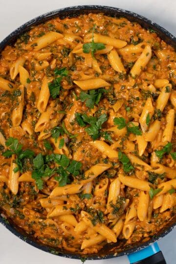 Top view of a pan with Creamy Kale pasta garnished with fresh parsley.