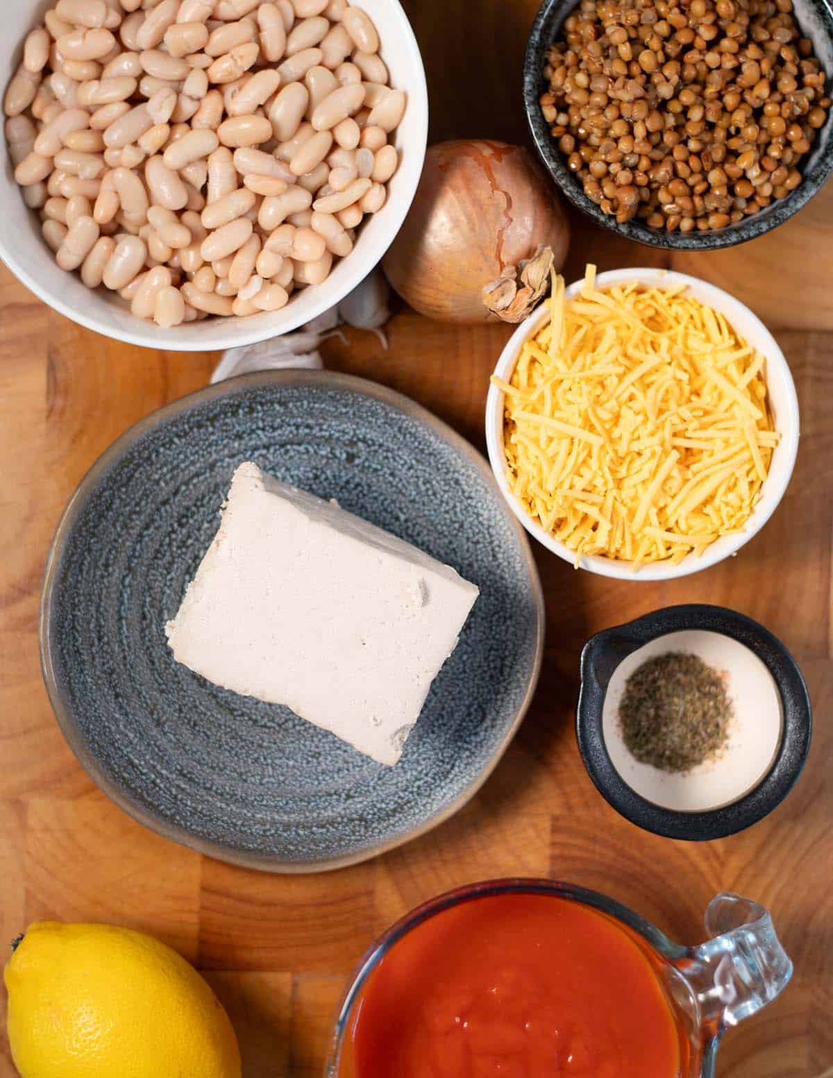 Ingredients needed to make Lasagna Beans collected before preparation in a wooden board.