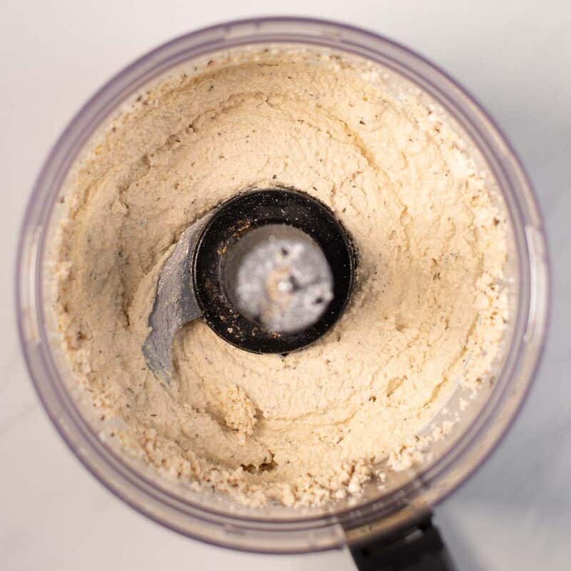 Ready smooth tofu ricotta in the bowl of a food processor.