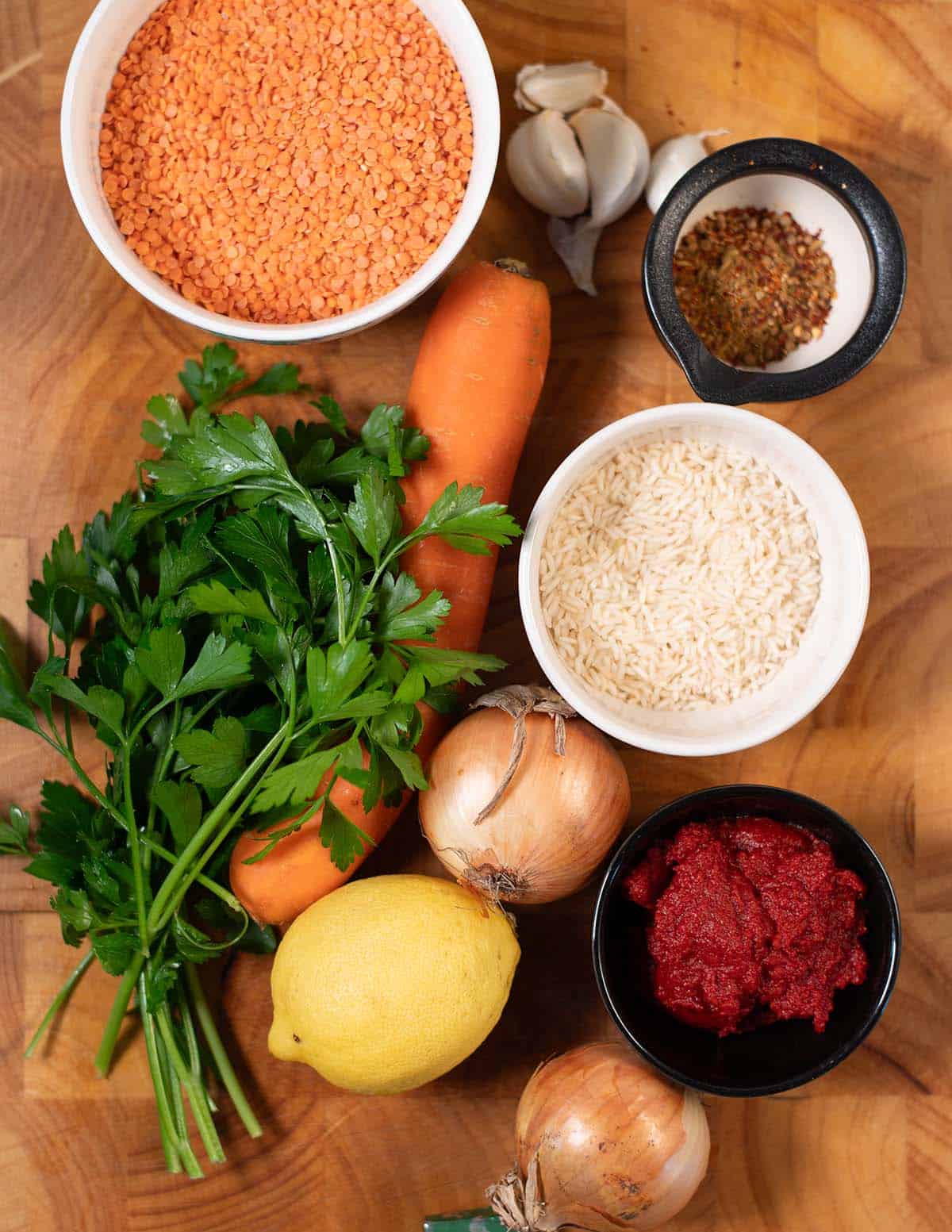 Ingredients needed to make Lebanese Lentil Soup collected on a board before cooking.