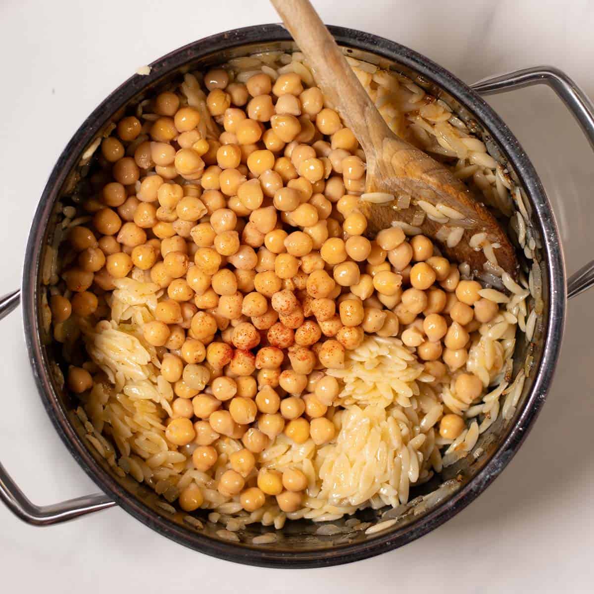 Pre-cooked orzo chickpeas and spices are given to the onions.