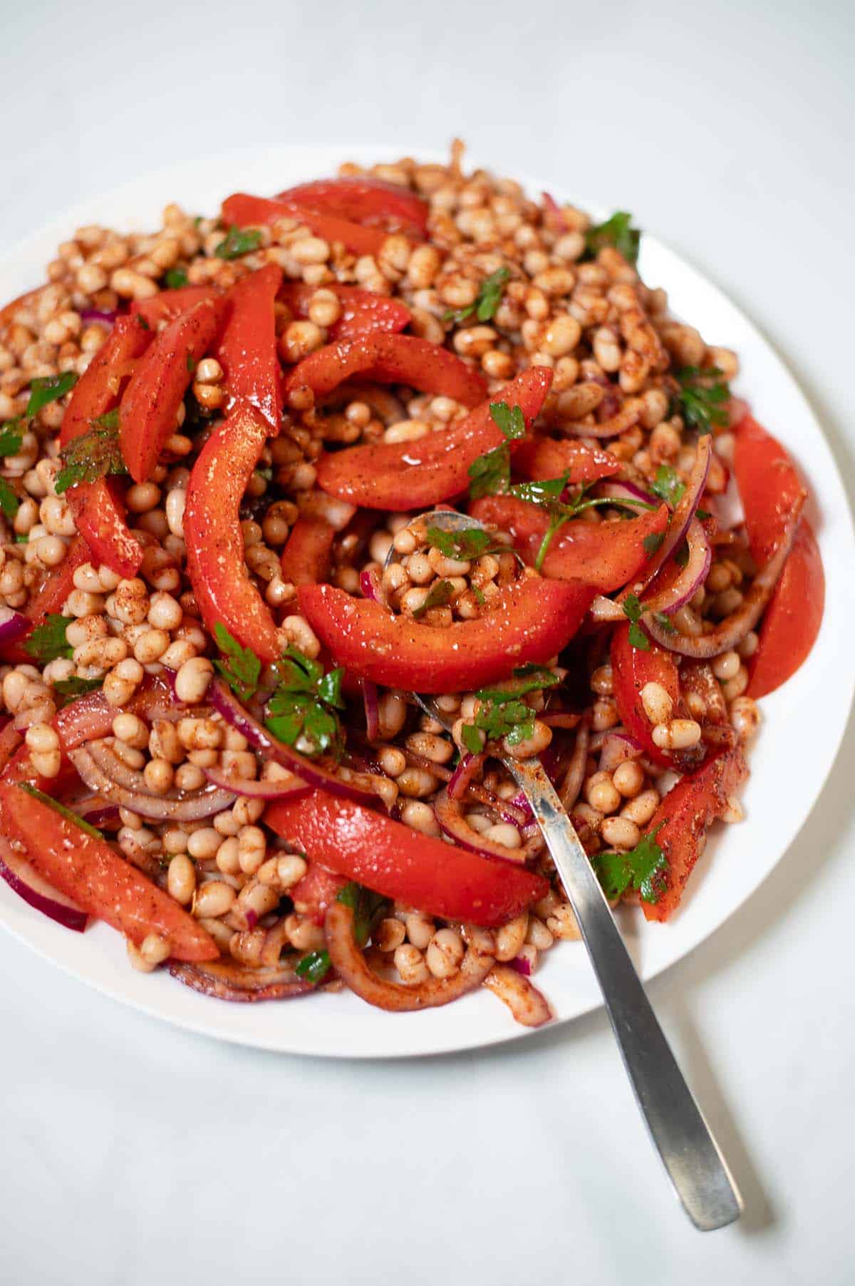A serving of Piyaz with a spoon.