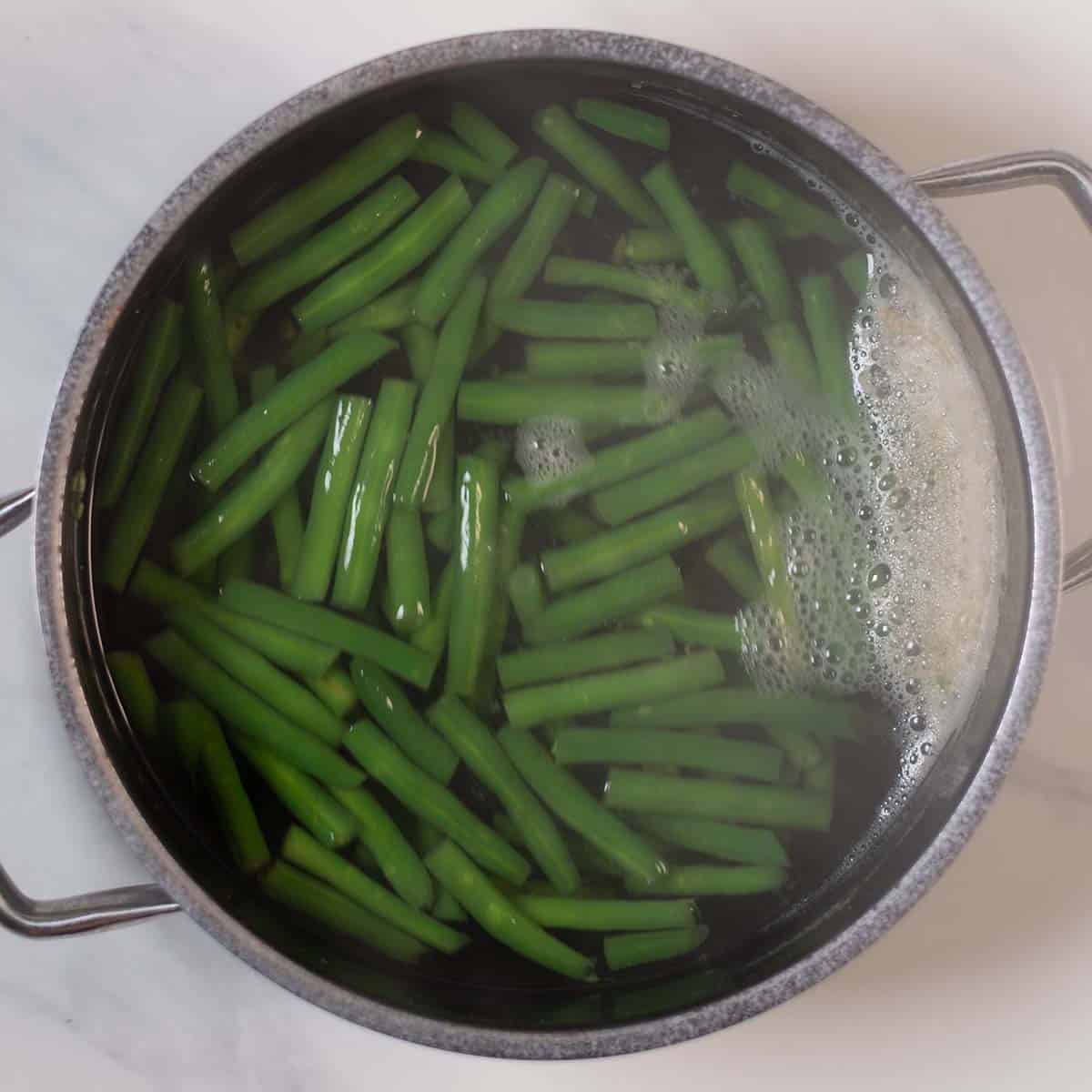 Green beans boiling in a pot for a healthy high-protein recipe.