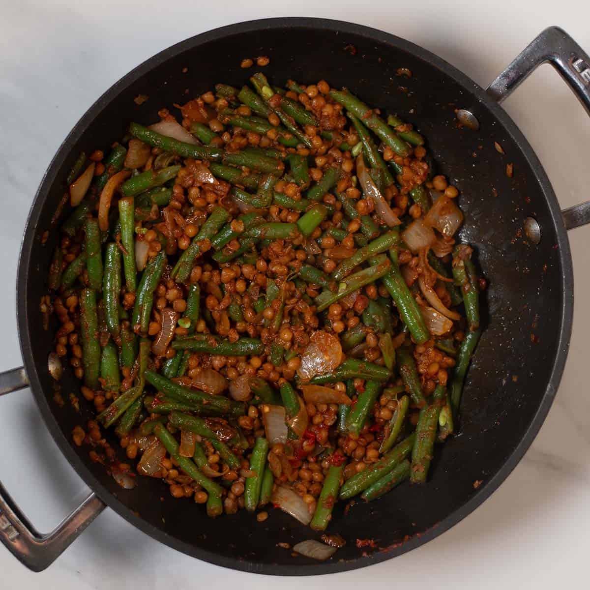 Green beans and lentils cooked in a skillet for a nutritious meal.