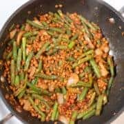 Green beans and lentils stir-fry in a black skillet for a high-protein meal.