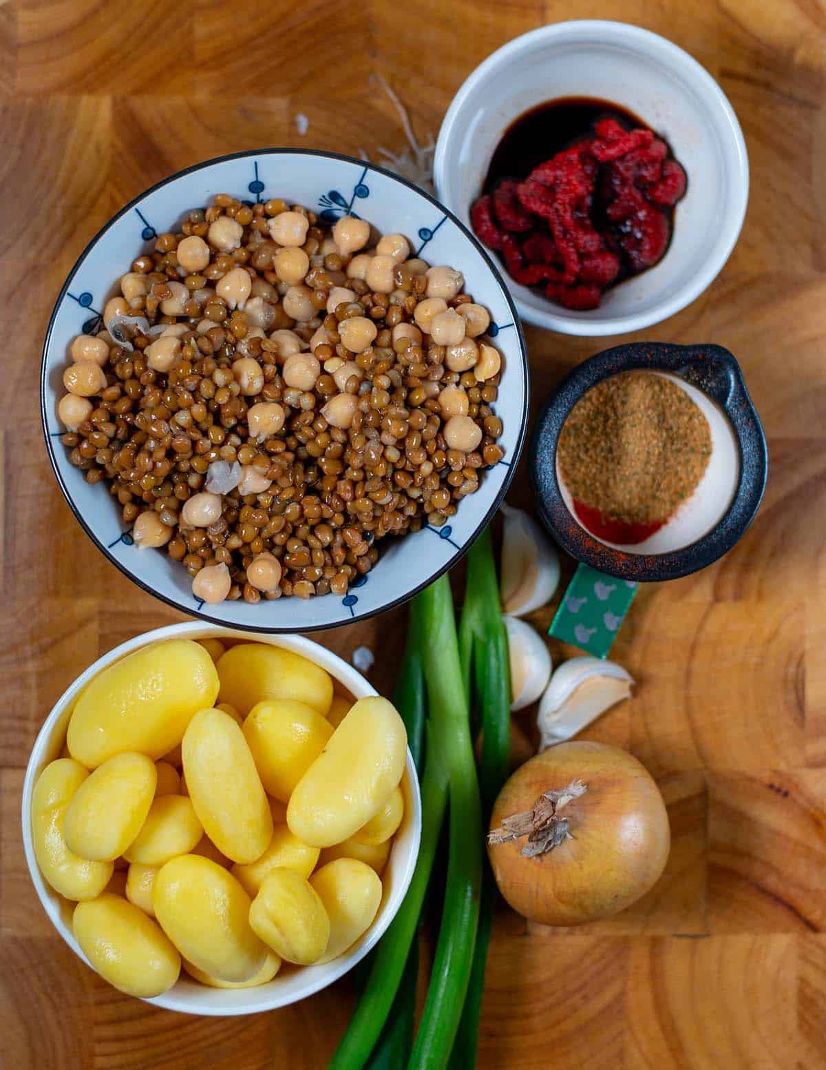 Assorted ingredients for Dirty Potatoes dish including potatoes, chickpeas, onions, and spices.