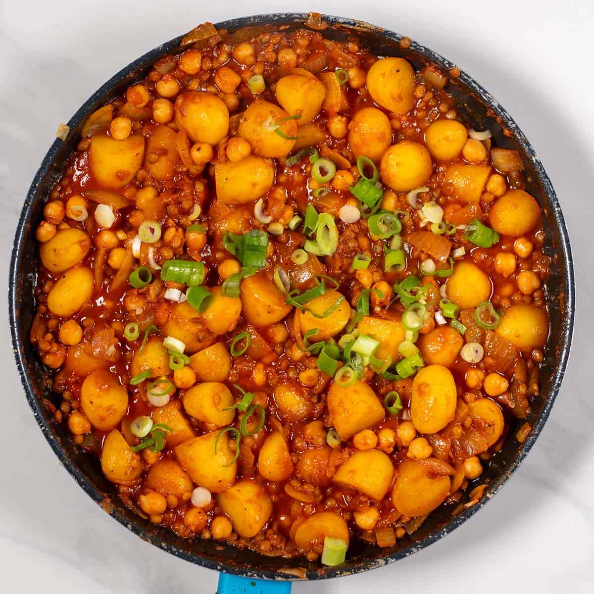 High-protein dirty potatoes with green onions in a skillet.