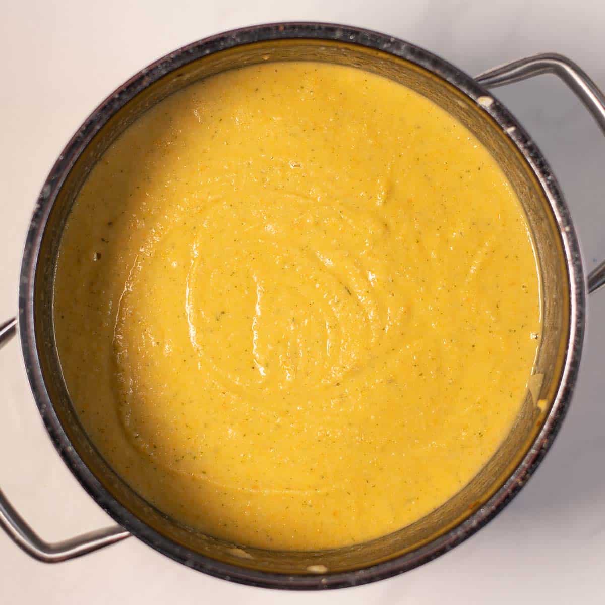Close-up of a creamy yellow chickpea soup in a pot.