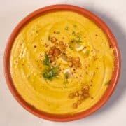 Creamy Greek chickpea soup served in a bowl with herbs and spices.