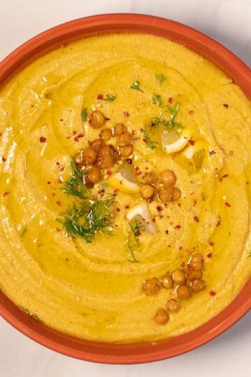 Creamy Greek chickpea soup served in a bowl with herbs and spices.