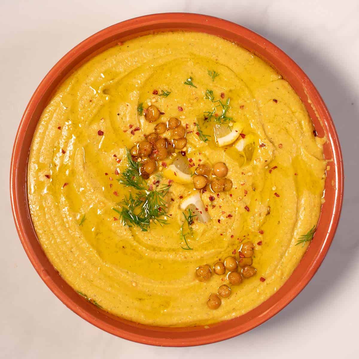 Creamy Greek chickpea soup served in a bowl with herbs and spices.