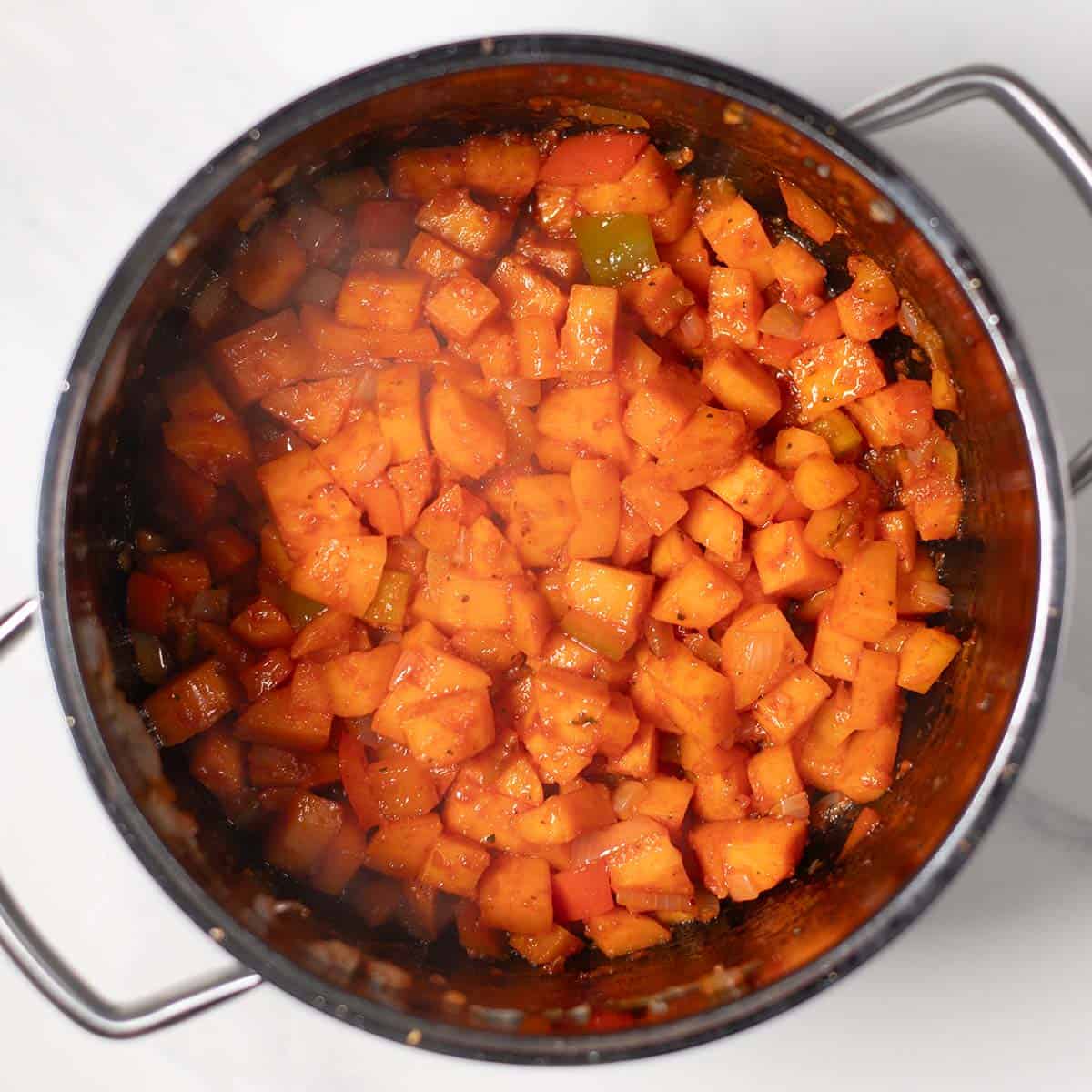 Cooked sweet potato and white bean chili in a pot, ready to serve.