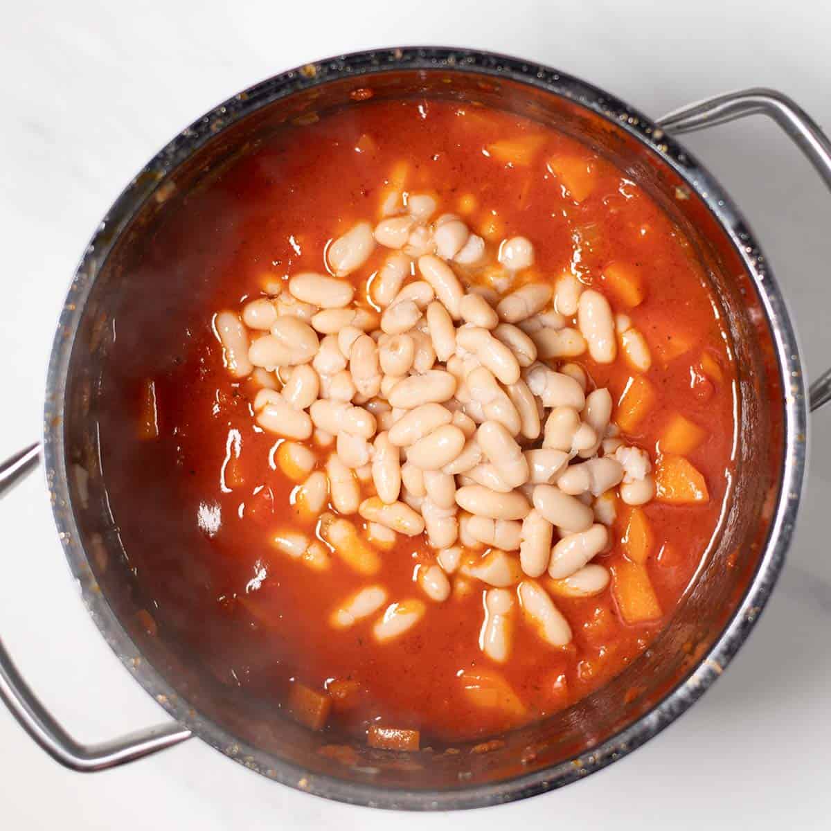 Hearty sweet potato chili with white beans in a pot, ready to serve.